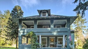 A two-story house with a porch, large windows, and a flag. - Private Beach Estate 6B, Group Friendly (Pacific County)