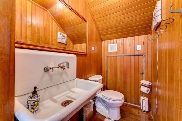 A wooden-paneled bathroom with a bathtub, toilet, and shower area. - Private Beach Estate 6B, Group Friendly (Pacific County)