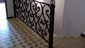 A staircase with a decorative metal railing and a checkered floor pattern.