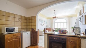 A kitchen with a microwave, refrigerator, and dishwasher. There is a wooden cabinet and a countertop with a kettle and cups. - Positano: Villa Mamma Rosa with spectacular sea views over the Amalfi Coast (Positano)