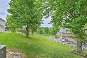 Stroll through a serene residential neighborhood with mature trees and a well-manicured lawn.