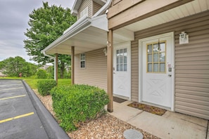 Guests enter through a charming covered porch with a white door and window above.
