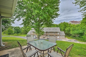 Relax in a serene outdoor seating area with a table and chairs under a tree, offering a view of the surrounding neighborhood.