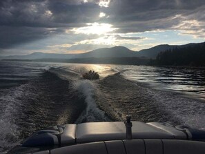 A boat moving through a body of water with mountains in the background.