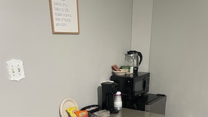 A small, neatly organized room with a table, a chair, a coffee maker, and a bowl of cereal. - Private Basement Room Pet Friendly Fenced Yard (Copperhill)