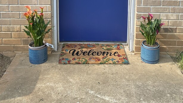 A blue door with a window, a welcome mat, and two potted plants. - Private Basement Room Pet Friendly Fenced Yard (Copperhill)