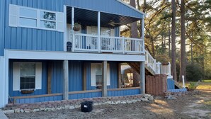 Une maison à deux étages dotée d’un balcon, d’un porche et d’un escalier en bois menant à l’étage supérieur.