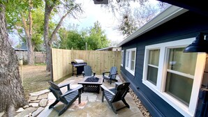 A patio with stone flooring, a grill, and outdoor furniture.