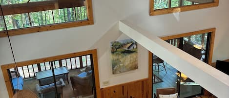 A spacious loft with high ceilings, large windows, and a dining area with wooden furniture.