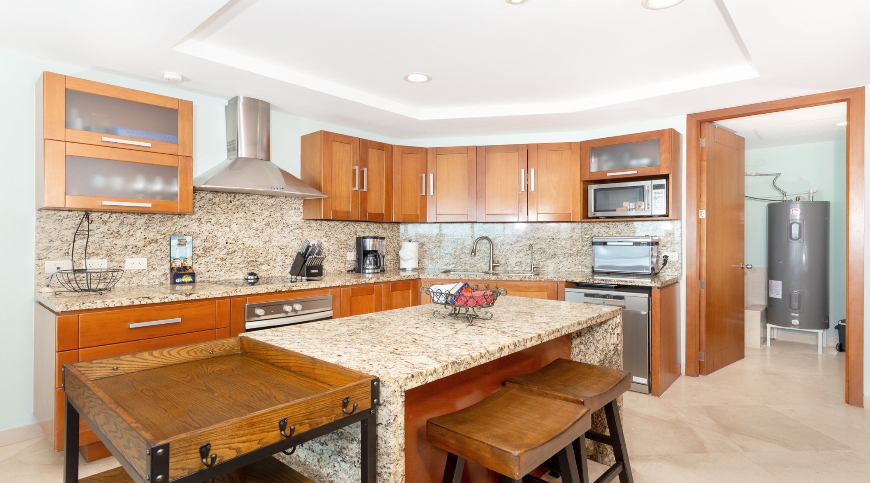A modern kitchen with granite countertops, wooden cabinets, stainless steel appliances, and a built-in oven.