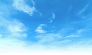 Escape to a serene atmosphere with a clear blue sky and scattered clouds.