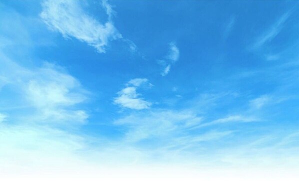 Escape to a serene atmosphere with a clear blue sky and scattered clouds.