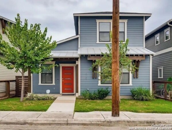Stunning two-story home with a charming front porch and beautifully landscaped yard.