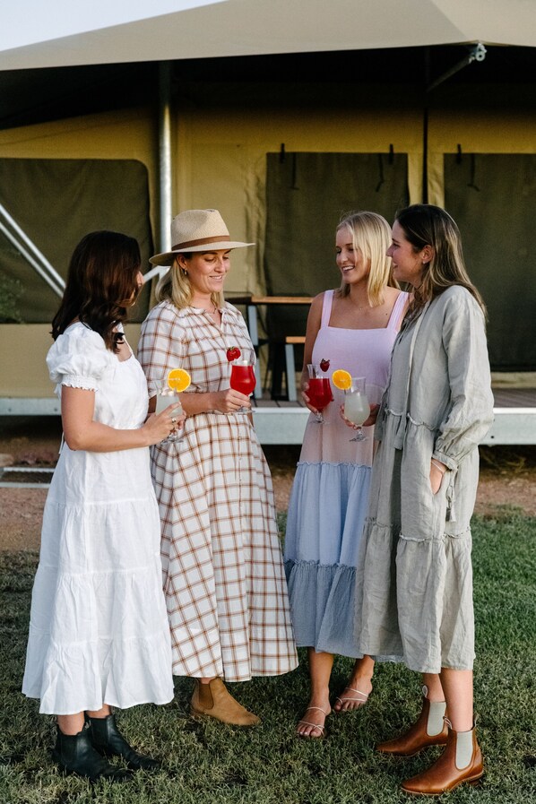Four people standing outdoors in front of a tent.