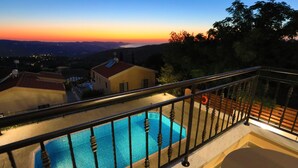 A swimming pool with a metal railing, surrounded by buildings and a view of the landscape during sunset. - Villa Salina: Modern Holiday Villa, Private Pool, Views, WiFi, A/C (Meladeia)