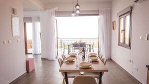 A dining area with a table set for six, a balcony with a view, and a modern interior design. - Villa Aeria: Holiday Villa To Rent, Pool, Views, WiFi, A/C (Meladeia)