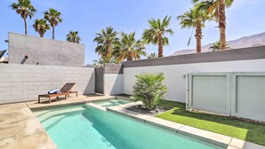 A swimming pool with a small garden area, palm trees, and a white wall. - Mid-Century Modern Palm Springs Home w/ Pool (Palm Springs)