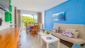 Una sala moderna con una mesa de comedor de madera, un sofá color beige y una pared azul de acento.