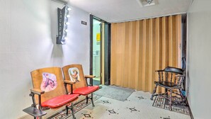 A room with two wooden chairs, one with a red seat and another with a black seat, and a small rug on the floor. - Peaceful Chadron Apartment in Historic Hotel! (Chadron)