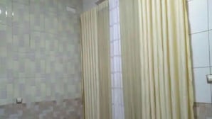 A room with a patterned tiled wall, a bed with a blue and white striped bedspread, and a window with beige curtains. - Pretty Kigali studio. (Kigali)