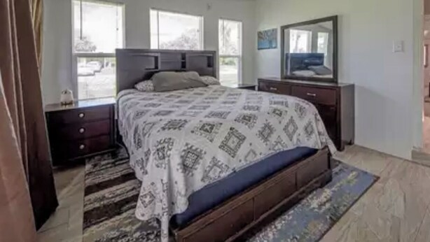 A bedroom with a bed, a dresser, a mirror, and a window. - Cozy little Home in Quiet neighborhood Off of major road (Port Charlotte)