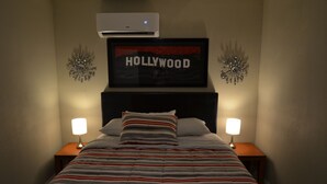 A hotel room with a bed, two bedside lamps, a framed picture of Hollywood, and decorative wall sconces. - 9min to the airport washer & dryer, kitchen, outdoor BBQ. Sleeps 4 (Las Vegas)
