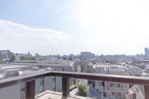A cityscape with multiple buildings, a clear sky, and a street in the foreground.