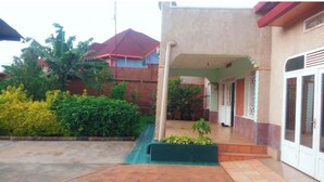 Un edificio con un portico, un vialetto in cemento e un piccolo giardino.