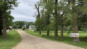 A gravel path leading to a house surrounded by trees. - Salt and Light Retreat for Overnight Stays in Rural South Dakota (Hayti)