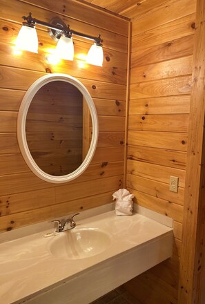 Een bad/douchecombinatie, handdoeken, shampoo, toiletpapier