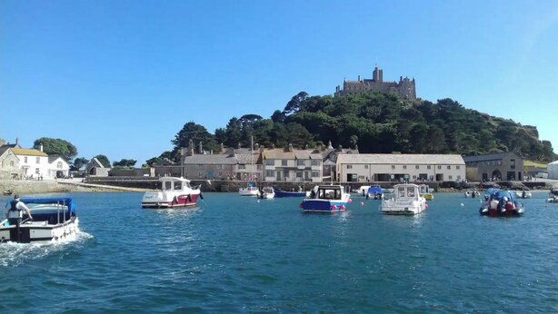 A harbor with boats, a castle on a hill, and buildings along the shore. - Grade 2 Listed Georgian Townhouse by the sea (Penzance)