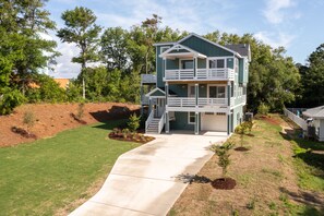 A two-story house with a front porch, a covered driveway, and a landscaped yard.