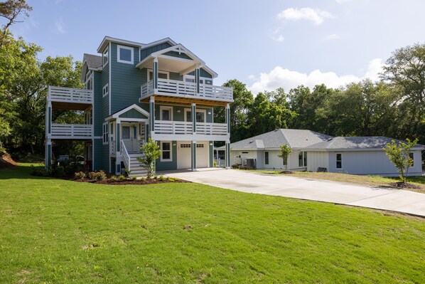 A two-story house with a balcony, a garage, and a well-maintained lawn.