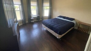 A bedroom with a bed, a desk, and a chair. - (F1) Convenient 3br Syracuse University apartment (Syracuse)