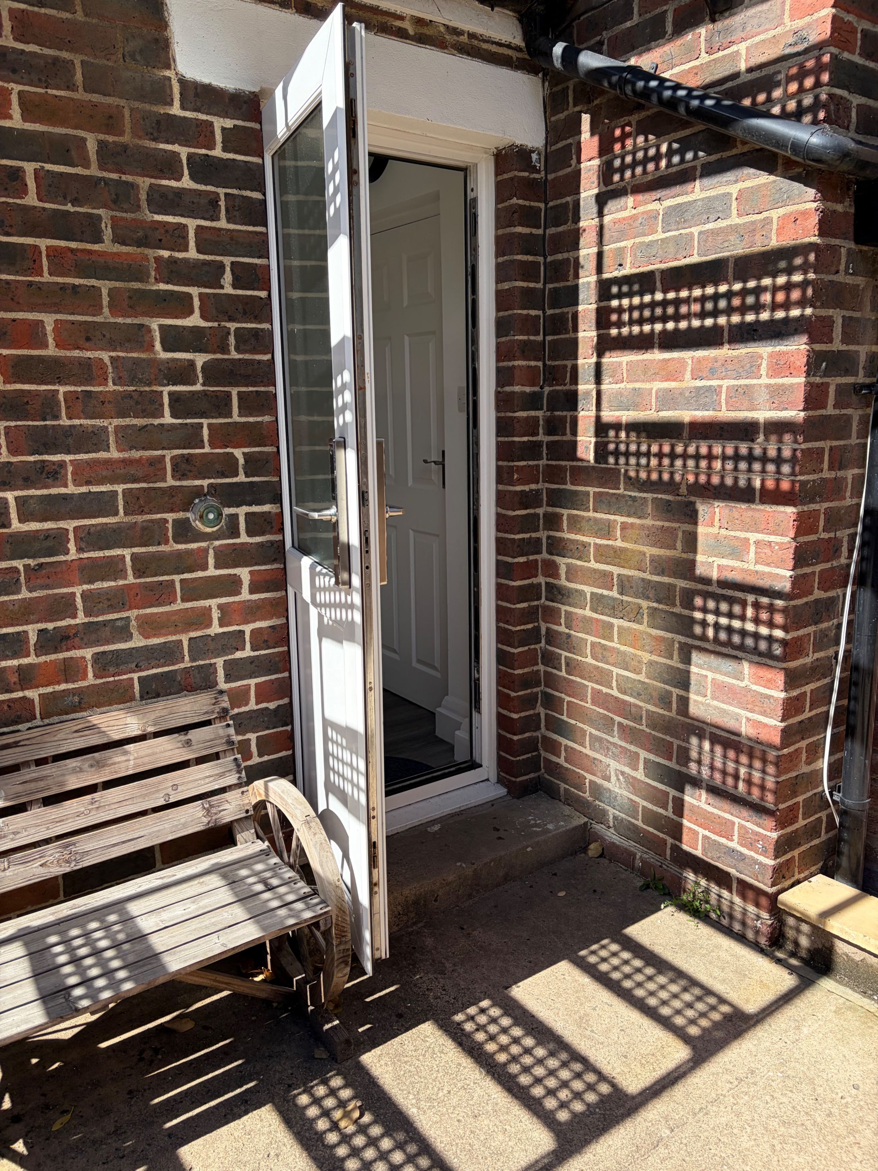 A brick wall with a door leading to an interior space.
