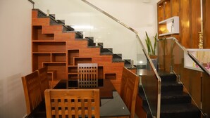 A modern staircase with glass railings, wooden steps, and a built-in shelf with decorative items.