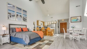 Een moderne slaapkamer met een groot bed, een eethoek en een keuken.