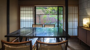 A traditional Japanese room with tatami flooring, a low table, and shoji screens. - Rinn Machiya Kuon (Kyoto)