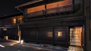 A traditional Japanese building with a wooden exterior, a tiled roof, and a balcony with railings. - Rinn Machiya Kuon (Kyoto)