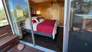 Une chambre à coucher avec un lit, un ventilateur de plafond et une table de chevet avec une lampe.