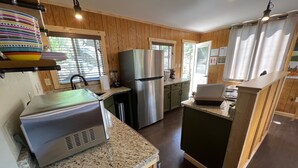 Une cuisine moderne dotée de plans de travail en granit, d’appareils électroménagers en acier inoxydable et de meubles en bois.
