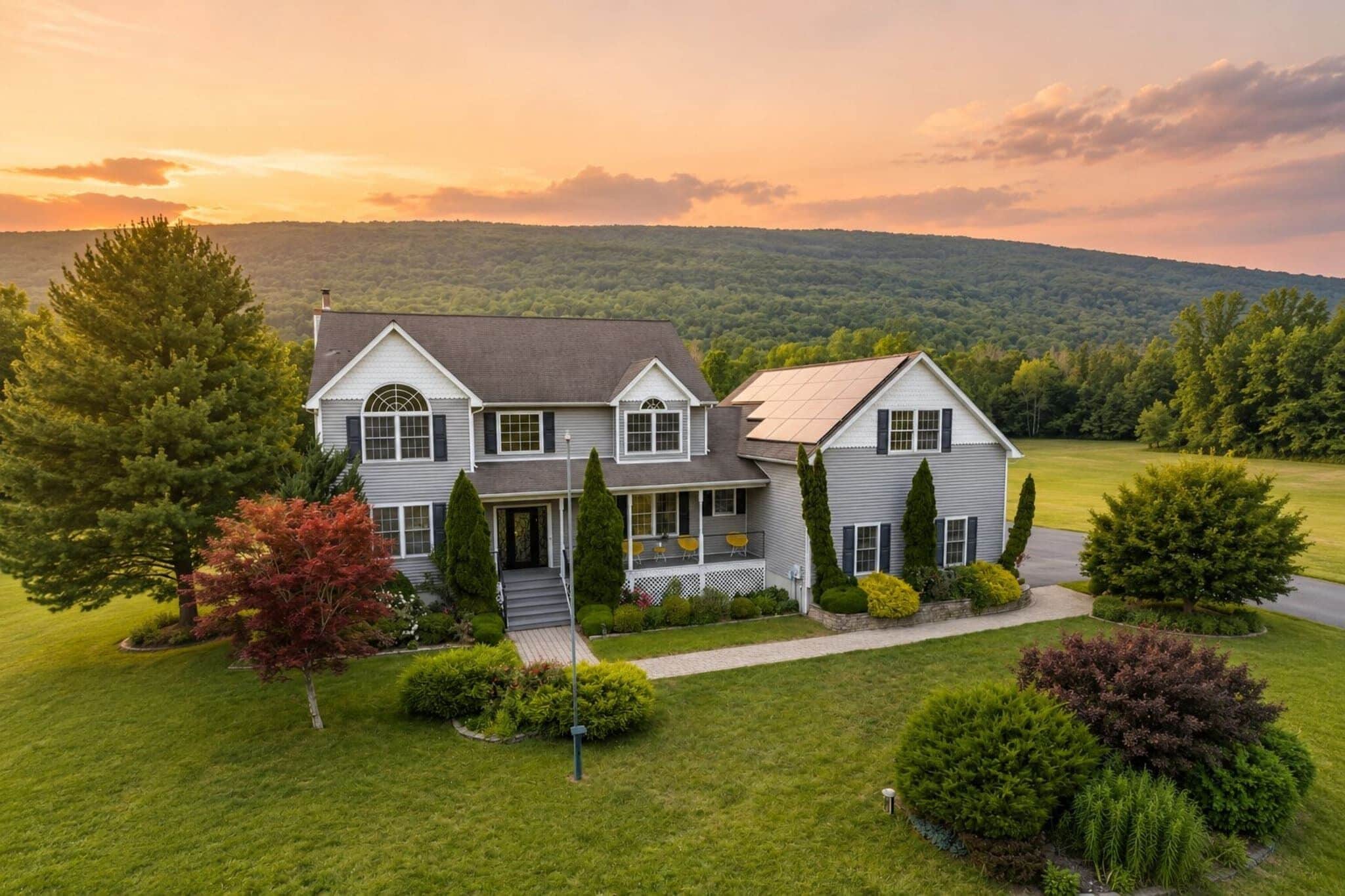 A two-story house with a front porch, surrounded by a well-maintained lawn and trees.