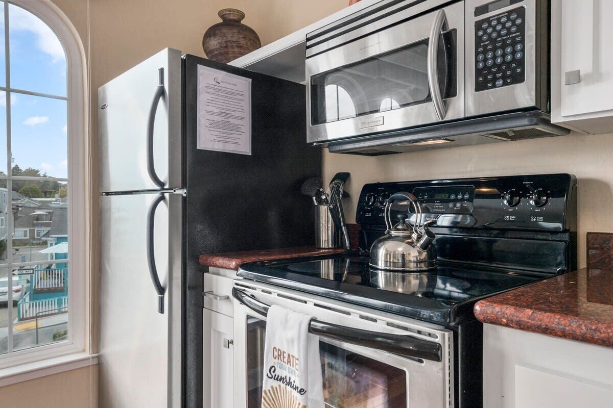 A kitchen with a refrigerator, microwave, stove, and oven.