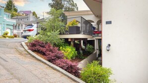A residential building with a balcony, a driveway, and a street view.