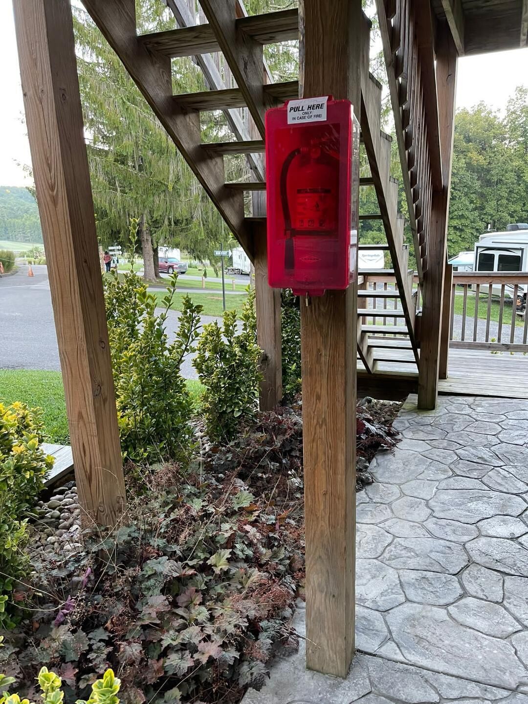 En pergola av trä med en röd nödstoppsknapp.
