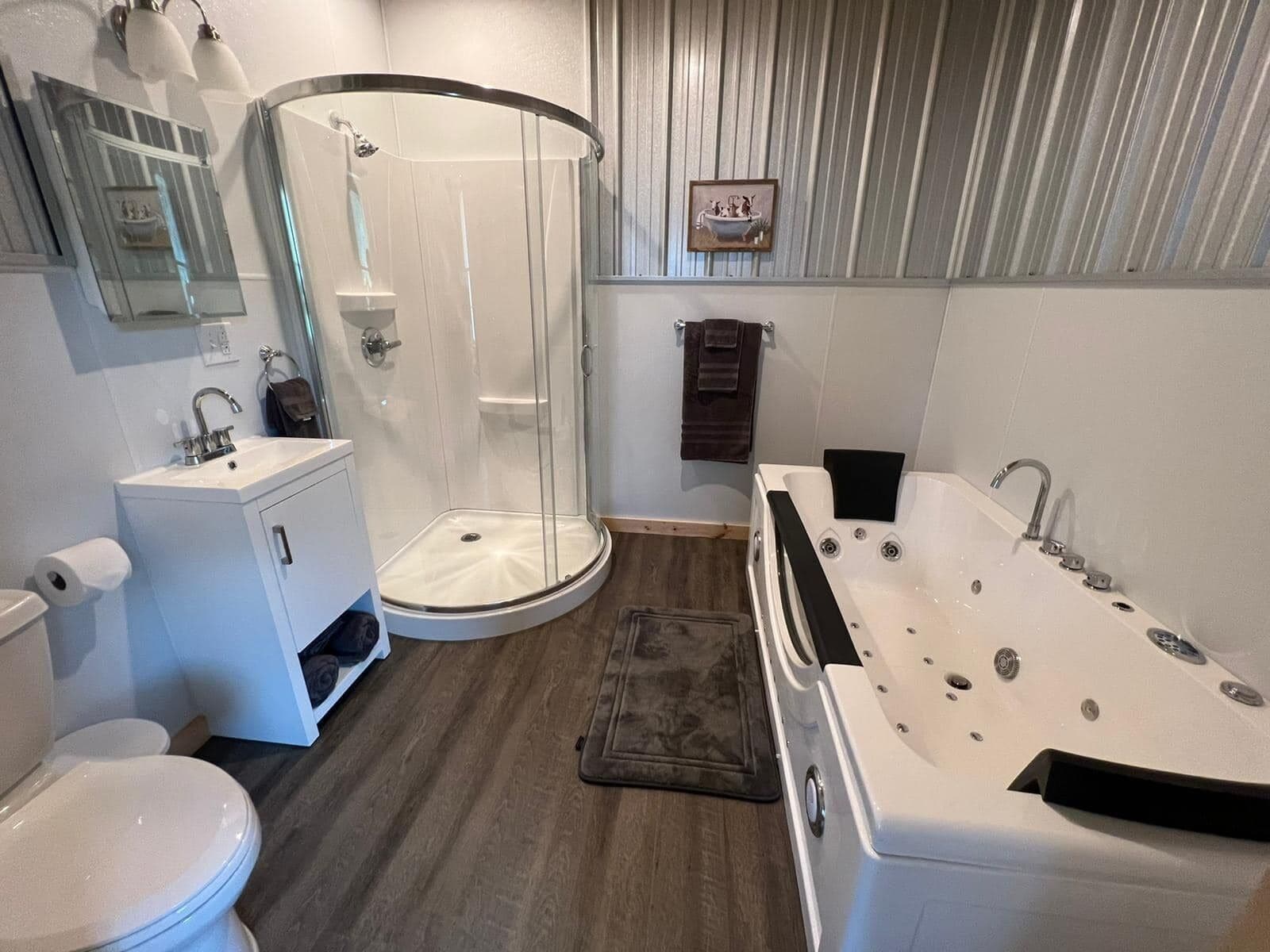 A modern bathroom with a toilet, sink, shower, and bathtub.