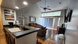 A modern kitchen with a central island, a built-in oven, and a coffee maker. - Relaxing Lake Conroe Condo overlooking the pool and lake (Montgomery)