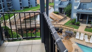 A residential building with multiple balconies, a swimming pool, and a landscaped garden. - Relaxing Lake Conroe Condo overlooking the pool and lake (Montgomery)