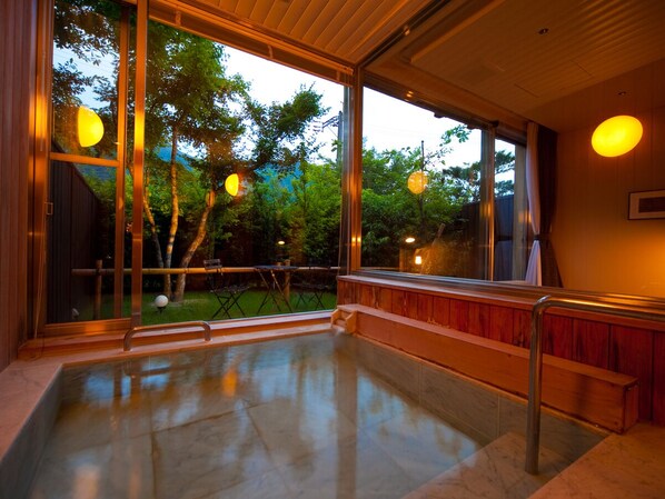 A spacious balcony with a glass railing, a wooden bench, and a view of trees and a building in the background. - YUFUIN UBLHOTEL (Yufu)