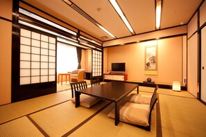 A traditional Japanese-style room with tatami flooring, a low table, and a television. - YUFUIN UBLHOTEL (Yufu)